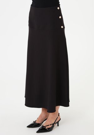 Black midi skirt with three decorative pearl buttons on the side, worn with black pointed-toe slingback heels.