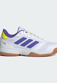 Chaussure de sport blanche avec des bandes violettes, languette jaune au talon, semelle en gomme et le texte "LIGRA" sur le côté, vue de profil.
