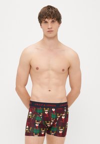 Boxer briefs featuring a festive reindeer pattern on a burgundy background, with a black waistband displaying the brand name "JACK & JONES."