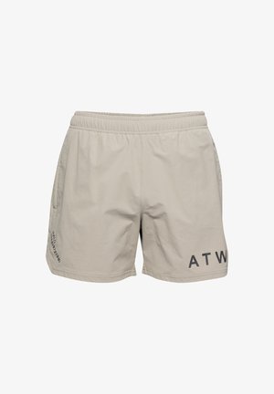 Helle beigen Shorts aus weichem Stoff mit einem elastischen Bund, seitlichen Taschen und einem dunklen Drucklogo am linken Bein.