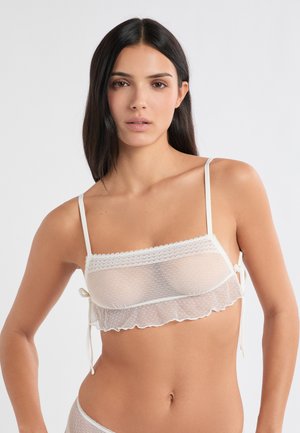 Bralette bianco in tessuto mesh morbido, con bordi arricciati e spalline regolabili. Presenta un bordo orizzontale in pizzo nella parte superiore.