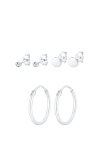 Ensemble de trois paires de boucles d'oreilles en argent : deux paires de clous avec des pierres transparentes et des clous circulaires simples, plus une paire de créoles brillantes.