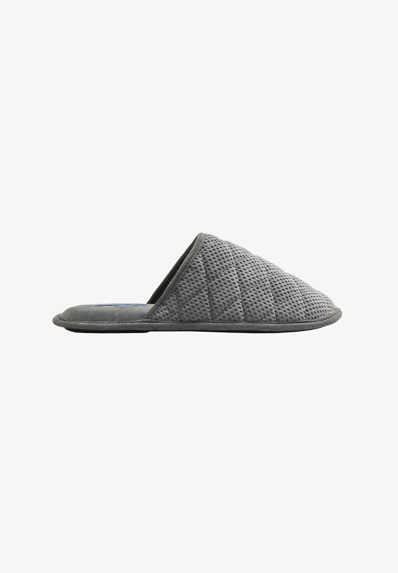 Zapatilla gris acolchada de perfil bajo, hecha de tela suave. Cuenta con un exterior texturizado y un forro interior suave para mayor comodidad.