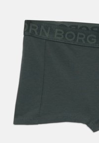 Tmavo zelené bavlnené boxerské šortky s textúrovaným pásom, na ktorom je v embosovanej typografii napísané "BORG". Hladká tkanina so šitými okrajmi.
