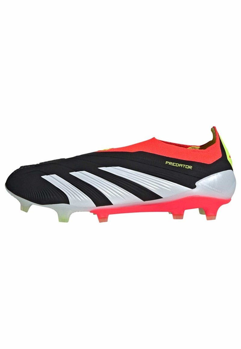 Crampons de football synthétiques noir et blanc avec une tige rouge, présentant des crêtes distinctes et une semelle rose. Comprend plusieurs pointes pour une traction optimale.