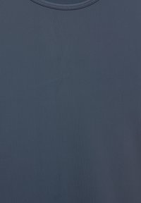 Temno modra tkanina z gladko teksturo in subtilnim vertikalnim vzorcem reber; ima zaobljen ovratnik s šivanimi robovi.