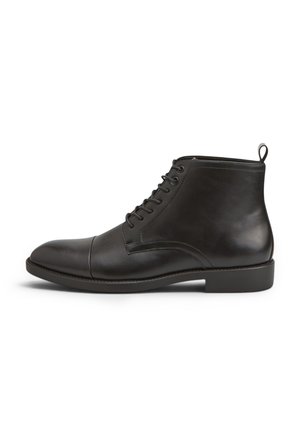 Stivaletto nero in pelle con lacci, tacco basso e linguetta posteriore, mostrato di profilo su sfondo bianco.