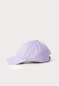 Boné de basebol lavanda feito de algodão, com aba curva e fivela ajustável. Possui seis orifícios de ventilação e uma textura macia.