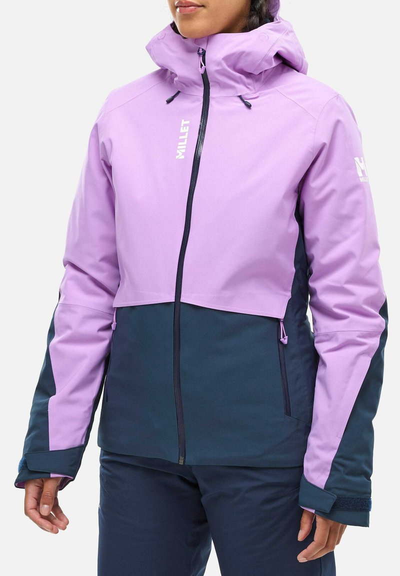 Veste impermeable violette et marine avec un col haut, une fermeture éclair à l'avant et des poignets ajustables ; présente un logo sur la poitrine et la manche.