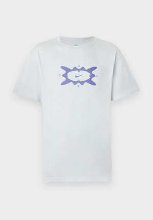 Valkoinen puuvillainen t-paita, jonka leikkaus on väljä. Keskellä purppuranvärinen graafinen kuvio, jota ympäröi aaltoileva kehys. Lyhyet hihat.