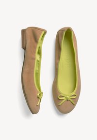 Ballet flats in tan suede with a matte finish. Features a neon yellow interior, matching bow detail at toe, and a low, sturdy heel.