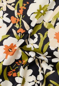 Ύφασμα με μαύρο φόντο που παρουσιάζει μεγάλα λουλούδια σε εκρού χρώμα, πορτοκαλί άνθη και φύλλα σε ελιά πράσινη απόχρωση, εμφανιζόμενο με φυσικές πτυχώσεις.