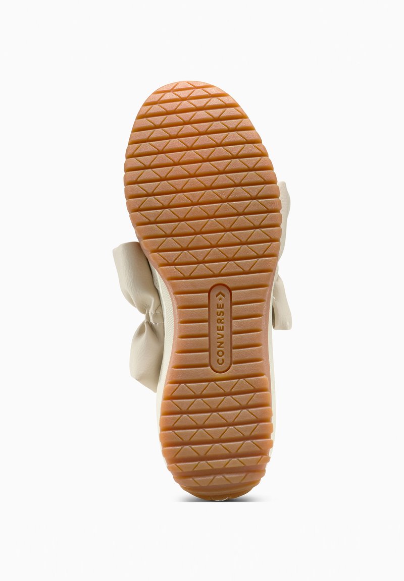 Rubber sole of beige Converse shoe with diamond and horizontal tread pattern and "CONVERSE" embossed in center.