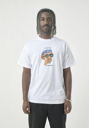 White cotton t-shirt with a graphic print of a person wearing sunglasses. Features text "LIVE SLOW" and "DIE OLD" above and below the drawing.