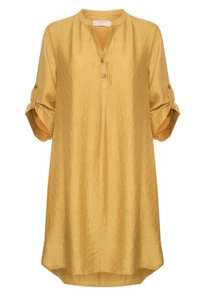 Tunique jaune moutarde en tissu froissé, dotée d'un col rond, de trois boutons et de manches retroussées avec des détails en bouton.