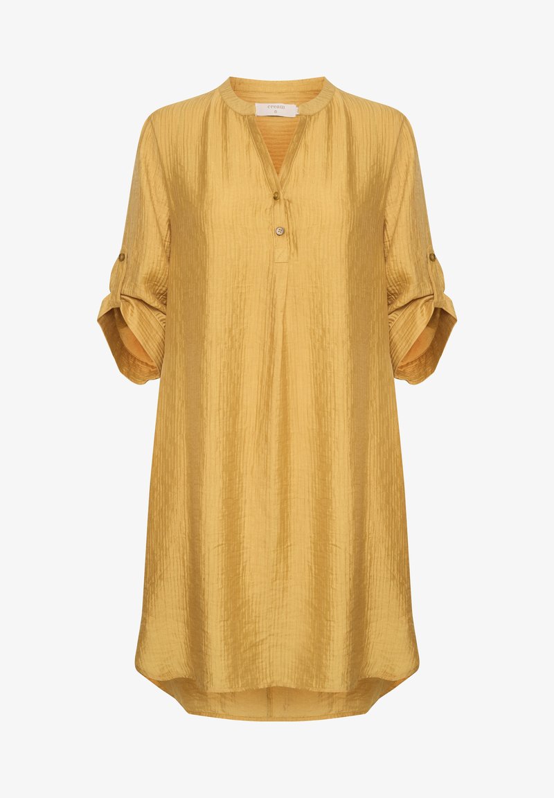 Musta kollane tunika särk, mis on valmistatud kortsulisest kangast, ümarate kaeluste, kolme nupu ja üles keeratud varrukatega, millel on nupu detailid.