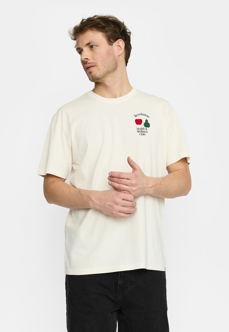Crème-kleurig katoenen t-shirt met korte mouwen, voorzien van een groen en rode afbeelding van een appel en peer met tekst op de linkerkant van de borst.
