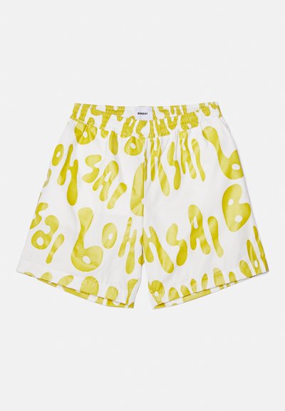 Weiße Shorts mit einem gelben abstrakten Muster. Bequemer elastischer Bund, lockere Passform und weicher Stoff. Markenzeichen auf der Rückseite.