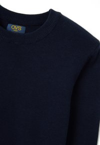 Pullover a maglia blu navy per bambini con colletto a girocollo a coste e texture morbida. Presenta un'etichetta con "OVS kids" in giallo.