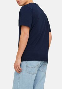 Marineblå bomulds t-shirt med korte ærmer, rund halsudskæring og afslappet pasform, parret med lyseblå denimshorts med baglomme.