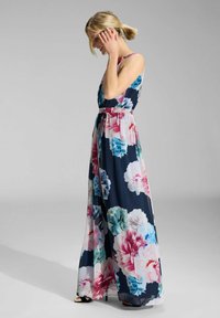Maxikleid mit floralem Muster in Marineblau, mit großen rosa, blauen und grünen Blumen. Glatter Stoff mit tailliertem Oberteil und fließendem Rock. Spaghettiträger.