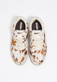 Sneakers z białą i brązową cętkowaną cholewa z bydlęcej skóry, beżowe sznurówki i ciemnobrązowa wkładka z logo "BIMBA". Płaska gumowa podeszwa.