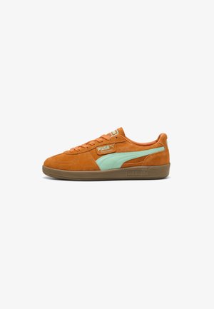 Oranje suède Puma Palermo sneaker met lichtblauwe streep en beige rubberen zool, zijaanzicht op een witte achtergrond.