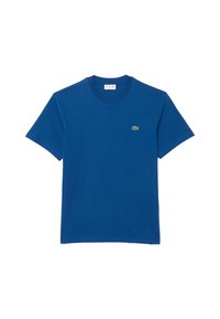 Camiseta de algodón azul con mangas cortas, cuello redondo y un pequeño logo del cocodrilo verde de Lacoste en el lado izquierdo del pecho.