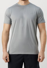 Camiseta deportiva de color gris claro con mangas cortas, escote redondo y una sutil textura de rayas horizontales. Presenta un pequeño logotipo en la parte delantera.