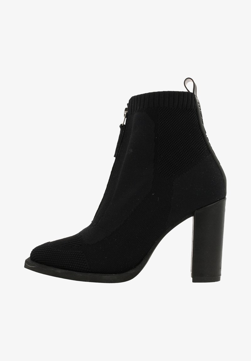 Bottine noire en tricot avec un talon carré, fermeture éclair sur le côté, motif texturé et patte de tirage à l'arrière.