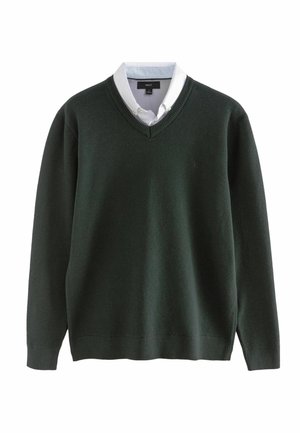 Tmavozelený sveter s výstrihom do V vyrobený z textúrovanej pleteniny, s dlhými rukávmi, ribovanými manžetami a s bielou košeľou s golierom navrstvenou pod ním.