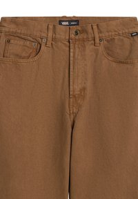 Pantalones de algodón marrón con cremallera, cierre de botón en la parte superior, diseño de cinco bolsillos y detalles cosidos. Presenta una etiqueta de Vans en la cinturilla.