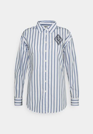 Witte blouse met lange mouwen, blauwe verticale strepen en een zwart geometrisch logo op de linkerborst.