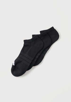 Tre par sorte ankelsokker med ribkant og et lille hvidt logo på tåområdet, lagt oven på hinanden på en ensfarvet lys baggrund.