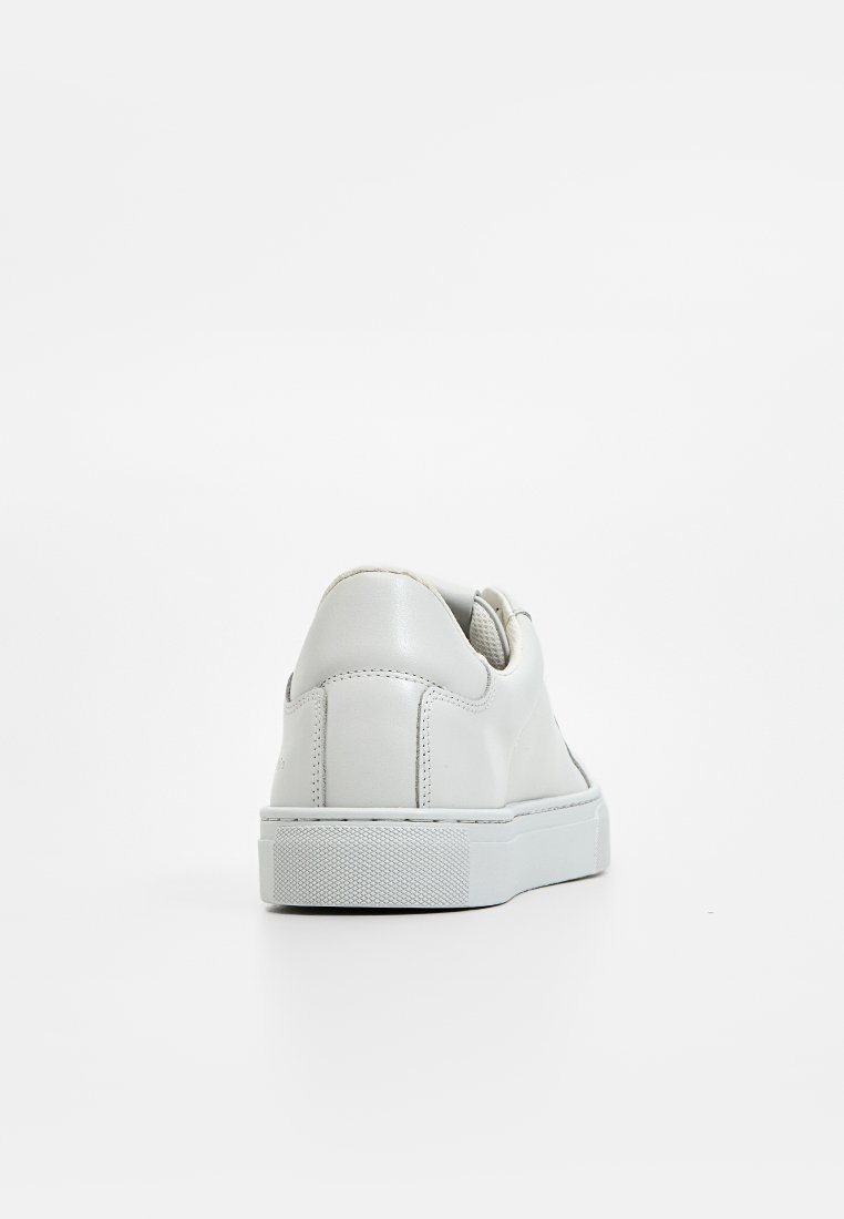 Weißer Ledersneaker mit glatter Textur, runder Ferse und kontrastierender Gummisohle. Verfügt über ein minimalistisches Design und kein sichtbares Branding.