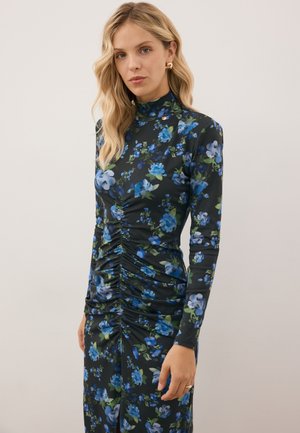 Sukienka na długi rękaw w ciemnej tkaninie z niebieskimi i zielonymi kwiatami. Charakteryzuje się marszczeniem z przodu, które dodaje faktury i kształtu.