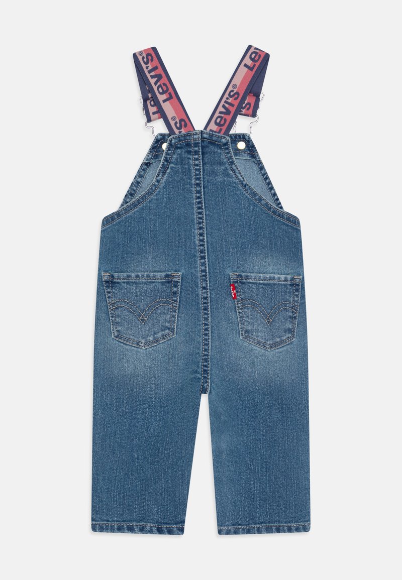 Denim-Latzhosen in Mittelblau mit verstellbaren Trägern und "Levi's"-Logo. Zwei Fronttaschen mit ikonischer Steppnaht.