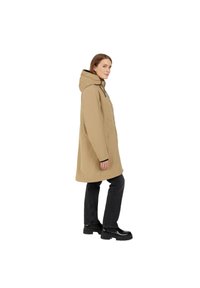 Beige Kapuzenparka mit lockerer Passform, ausgestattet mit Seitentaschen und kontrastierenden schwarzen Bündchen, getragen zu schwarzen Jeans und klobigen schwarzen Stiefeln.