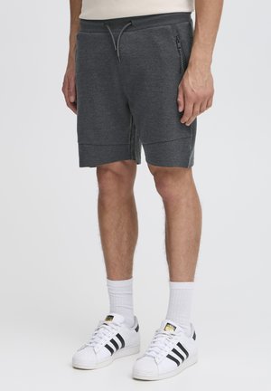 Graue Baumwollmischungsshorts mit elastischem Bund und Kordelzug, ausgestattet mit seitlichen Reißverschlusstaschen und einer lockeren Passform, die oberhalb der Knie endet.