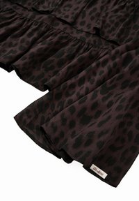 Rypistettävä hame leopardikuosisena tumman violetin ja mustan sävyissä, jossa on röyhelöreunat ja pieni brändätty tagi helmassaan. Kevyt kangas.