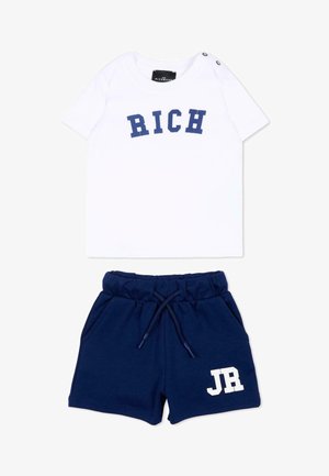 Witte korte mouw shirt met 'RICH' in blauwe letters en marineblauwe shorts met trekkoord en 'JR' in wit op het been.