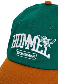 Gorra verde y marrón con el logo de Hummel, que presenta letras blancas bordadas y una abeja. Hecha de algodón, muestra un diseño estructurado.