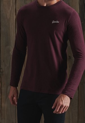 Bordowa koszula z długim rękawem wykonana z miękkiego materiału, z okrągłym dekoltem i małym haftowanym logo na lewej piersi.