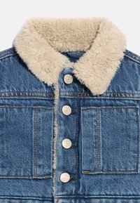 Džinsa jaka ar brūnganu mākslīgā vilnas apkakli, pieciem sudraba pogām, diviem priekšējiem kabatām un zilu džinsa audumu ar oranžām šuvēm.