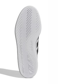 Adidas potplat, gumeni materijal, teksturiran s cik-cak uzorkom, pretežno bijele boje s crnim naglascima sa strane. Prisutno brendiranje.