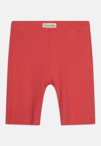 Crvene pletene pamučne kratke hlače uskog kroja s elastičnom stražnjom trakom. Imaju označeni Calvin Klein logo pri vrhu.
