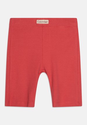 Crvene pletene pamučne kratke hlače uskog kroja s elastičnom stražnjom trakom. Imaju označeni Calvin Klein logo pri vrhu.
