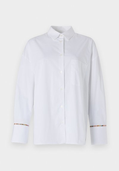 Biela košeľa s dlhým rukávom a gombíkmi vyrobená z hladkej tkaniny, vybavená náprsníkom a farebným pruhovaným akcentom na manžetách.