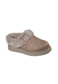 Bruine neplederen klomp met een zachte, beige bontkraag, een gestructureerde bovenkant en een flexibele tan-gekleurde zool. Gouden hartlogo aan de zijkant.