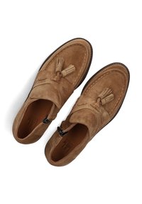 Bruine suede instappers met franjes, vlakke zolen en contrasterende stiksels. Rond afgesneden neus met een zachte textuur en een strak ontwerp.